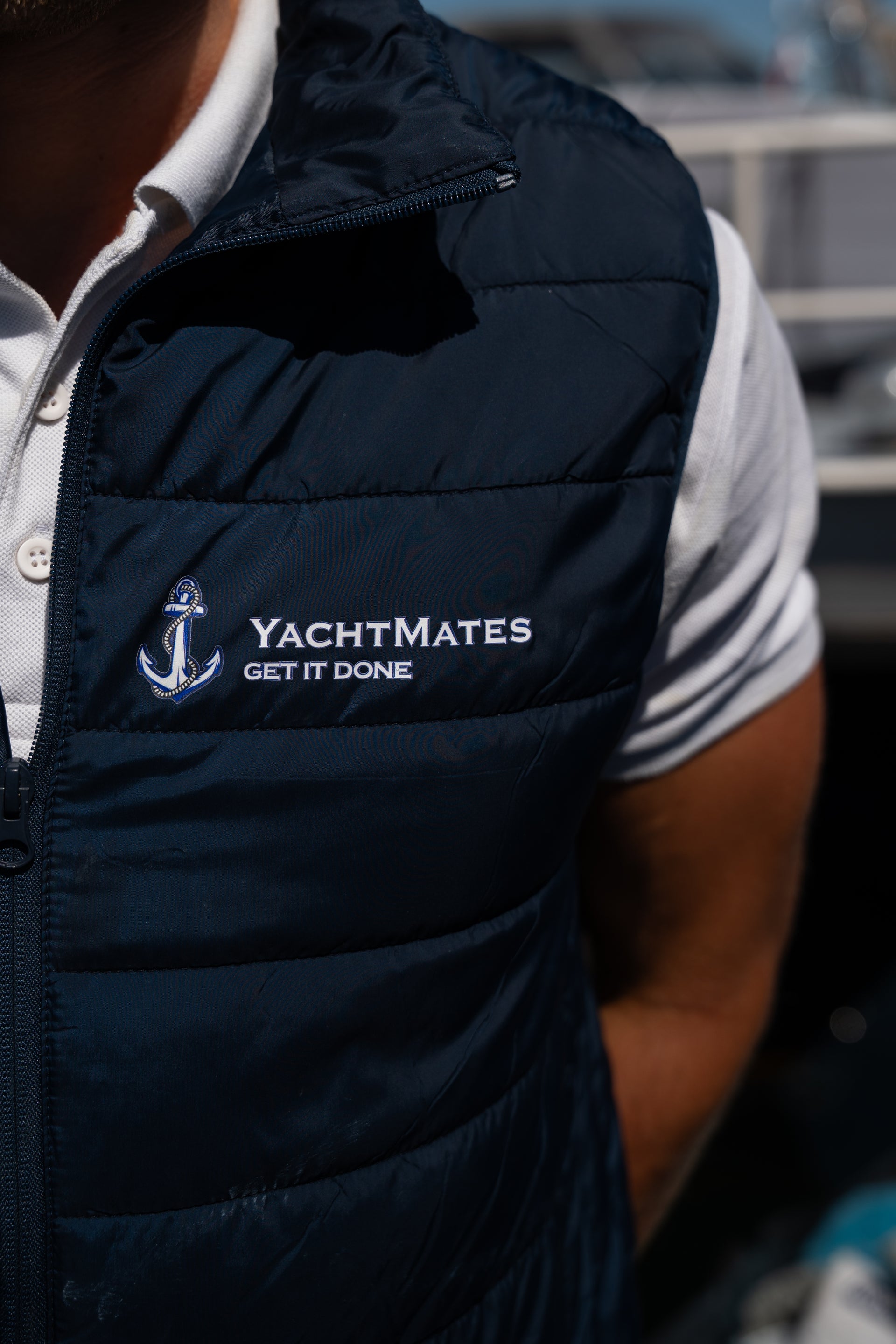 YachtMates bodywarmer met logo tijdens professioneel bootonderhoud in de haven.