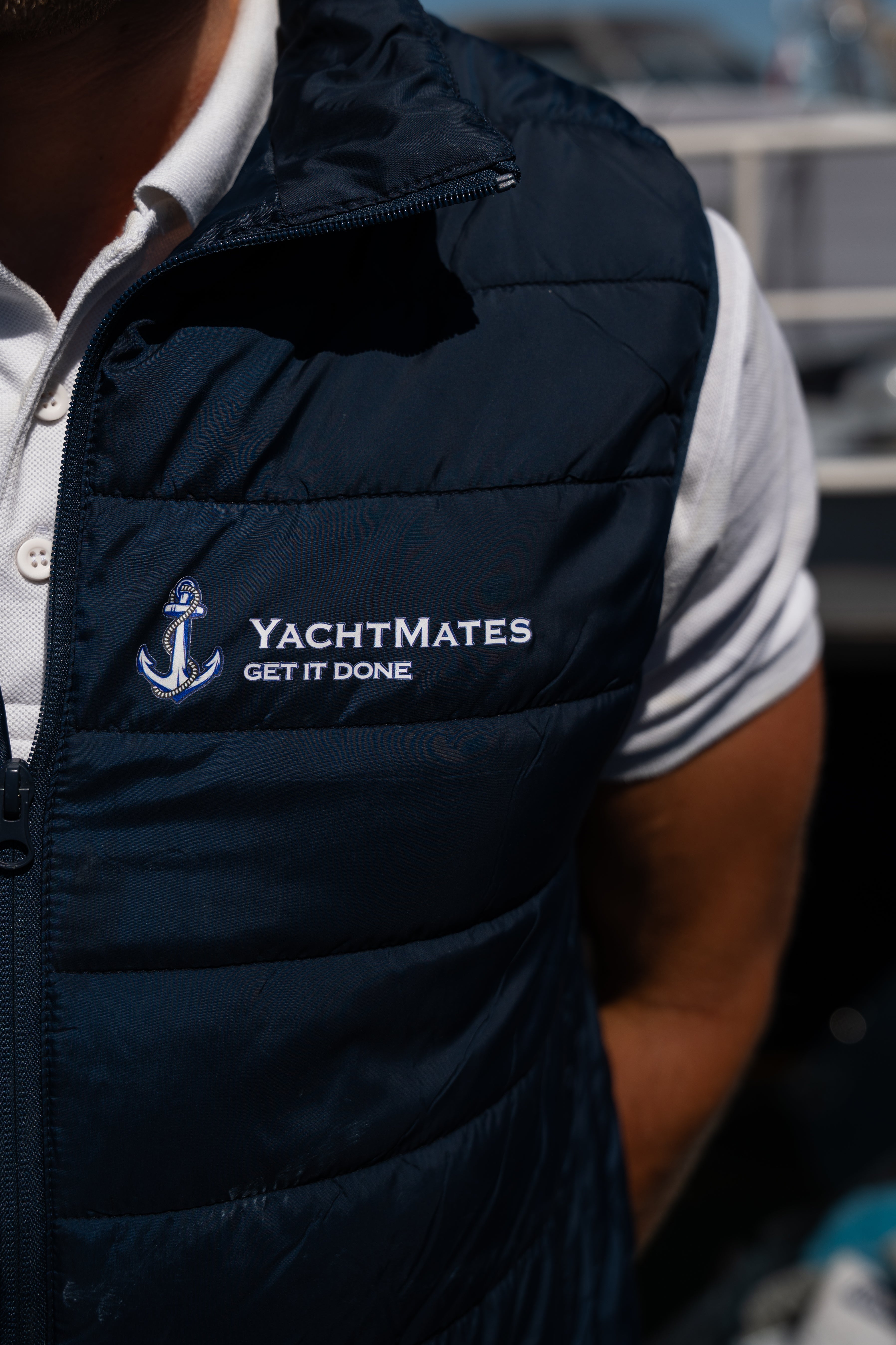 YachtMates bodywarmer met logo tijdens professioneel bootonderhoud in de haven.